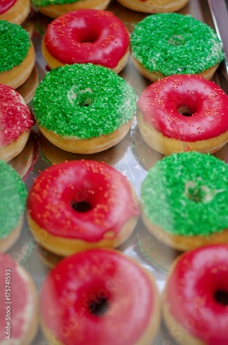 Verschiedene Donuts, rot und grün glasiert und Streuseln. 