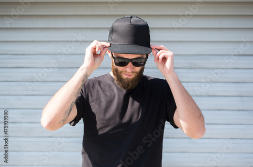 Hipster man wearing black T-shirt and a black hat with space for logo