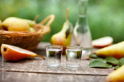 Shot glass and pears in the background