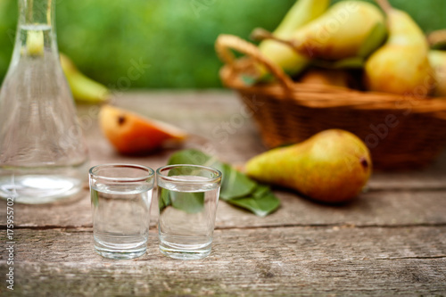 Pear brandy in shot glass.Pears in background.