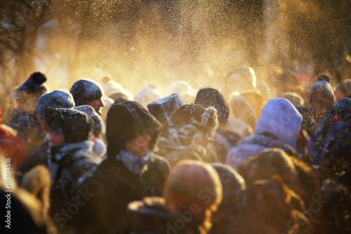 Zdjęcie XXL Zamazany tłum ludzi w winter park. Ładne, ciepłe światło z cząstkami śniegu
