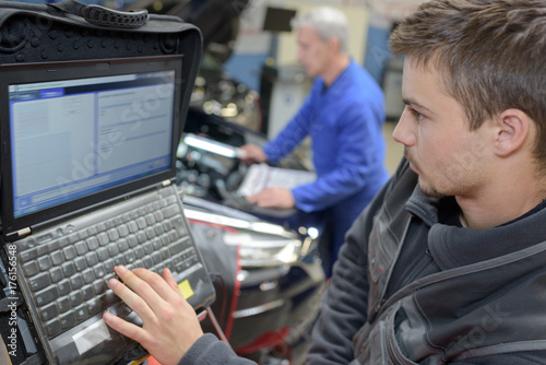 Zdjęcie XXL nauczyciel mechanika samochodowego i praktykant przeprowadzający testy w szkole mechanicznej