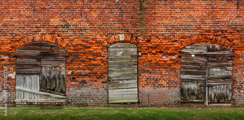 Old bricks wall texture with doors and shutters.