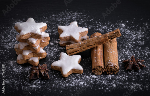 Zimtsterne mit Zimtstangen und Anissternen auf dunkelem Hintergrund