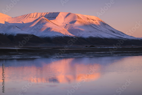 Landscape of a nature of a pink sunset in the reflection ocean mountains of Spitsbergen Svalbard near the Norwegian city Longyearbyen