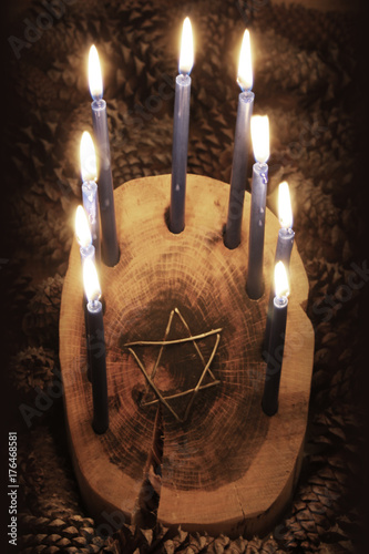 Zdjęcie XXL Widok z przodu drewnianego kłody Menorah Chanuka z inicjałem drutu Star of David, zapalone świece