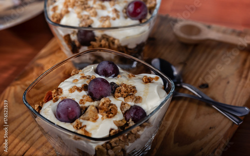 Plakat Jogurt, granola, miód i winogrona zebrane w domu serwowane w szklanej misce