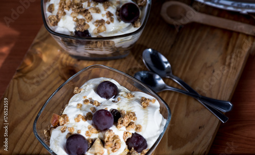 Plakat Jogurt, granola, miód i winogrona zebrane w domu serwowane w szklanej misce