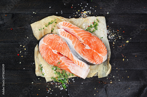 Salmon steaks on black wooden table top view