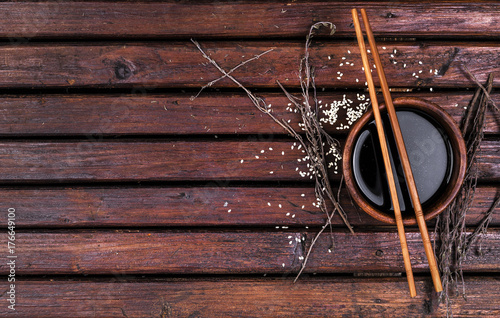 Soy sauce and chopsticks on a wooden table top view