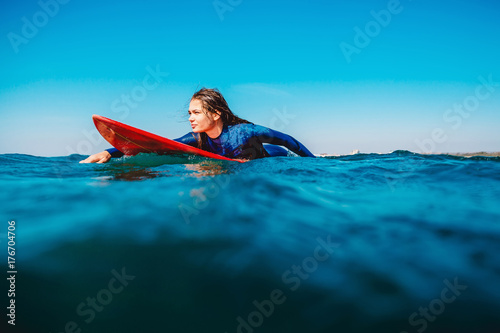 Plakat Surf girl unosi się na desce surfingowej. Kobieta w oceanie podczas surfowania. Surfer i ocean