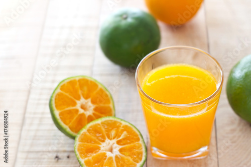 Orange juice glass and oranges fruits on wooden background