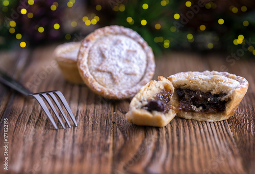 Traditional, british Mince Pies, cracked open on a wooden background