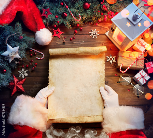 Santa Claus Desk Reading Wish List With Ornament And Christmas Gift
