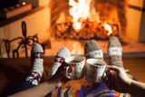 A man and a woman in front of a fireplace in warm socks. New Year. Christmas.