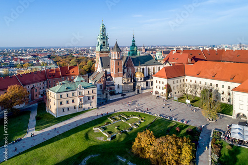 Zdjęcie XXL Królewska Katedra gotycka na Wawelu w Krakowie, z renesansową kaplicą Zygmuntowską ze złotą kopułą, częścią Zamku na Wawelu, podwórzem, parkiem i turystami. Widok z lotu ptaka o zachodzie słońca w upadku