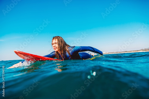 Plakat Surfer dziewczyna na deskę surfingową. Kobieta w oceanie podczas surfowania.