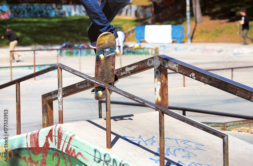 Zdjęcie XXL młody skater skacze na balustradzie w skateparku / miejski skater robi sztuczki na balustradzie w skateparku
