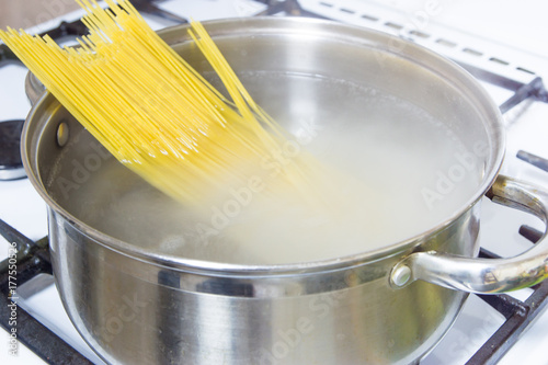 Fotoobraz na płótnie Spaghetti gotowane we wrzącej wodzie na kuchence gazowej.
