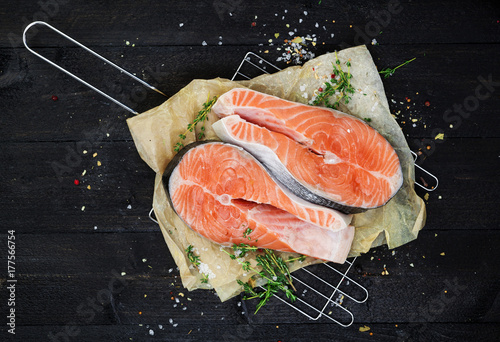 Salmon steak on black wooden table top view