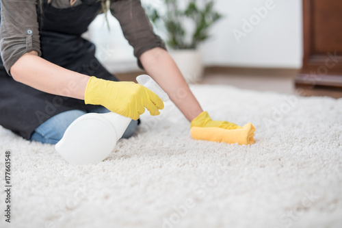 Housewife cleaning carpet.