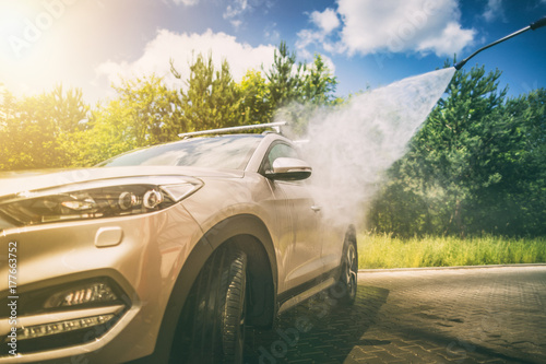 Manual car wash with pressurized water.