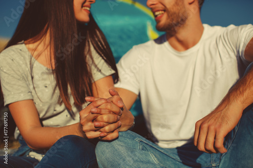 Happy young couple holding hands in nature. Focus on hands.