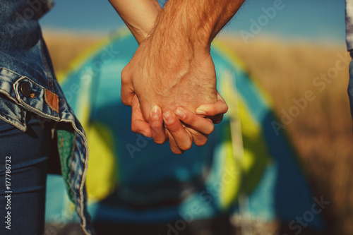 Young couple holding hands at camping