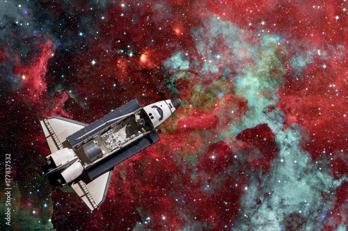 Space Shuttle over galaxy and space nebula. Elements of this image furnished by NASA.