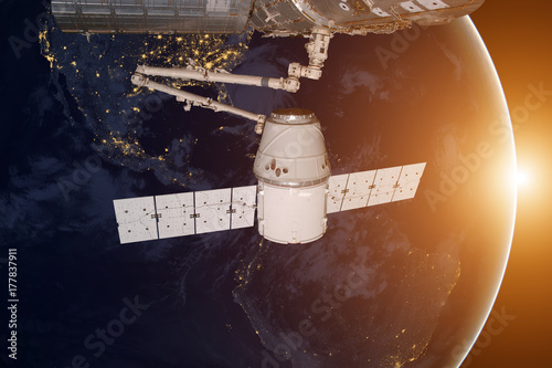 SpaceX Dragon orbiting the planet Earth. Elements of this image furnished by NASA.