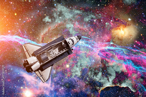 Space Shuttle over galaxy and space nebula.