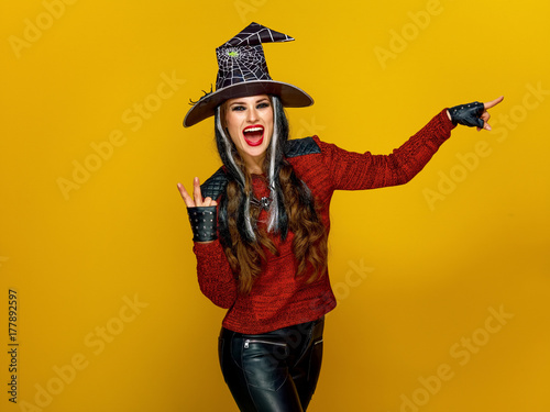 smiling woman pointing at something and showing victory