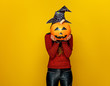 woman holding sad jack-o-lantern pumpkin in front of face - 177892921