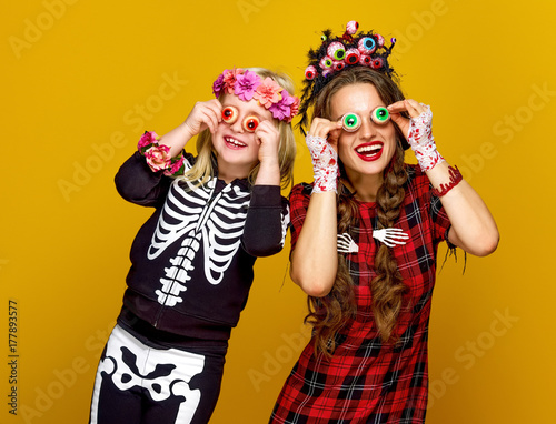 mother and daughter in halloween costume having fun time
