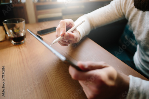 Man using tablet pc with a pencil at a desk