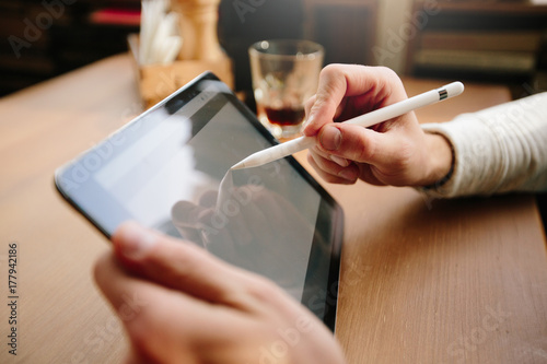 Man using tablet pc with a pencil at a desk