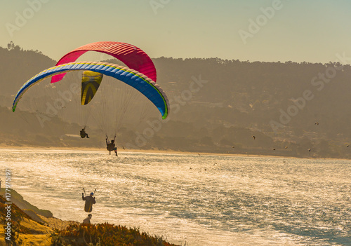 Fotoobraz na płótnie Paragliding nad plażą i ocean w Monterey zatoce przy zmierzchem
