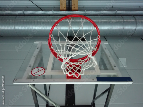 Zdjęcie XXL Widok z dołu od boiska do koszykówki, przez obręcz do koszykówki, do oświetlonego sufitu hali sportowej