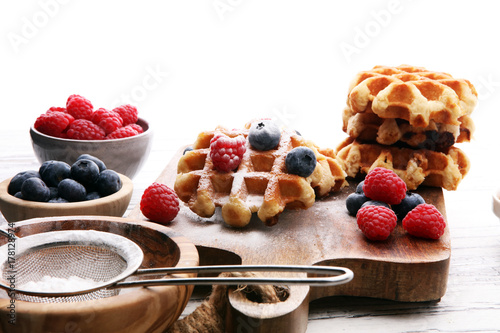 Traditional belgian waffles with fresh blueberries, sugar and raspberries.