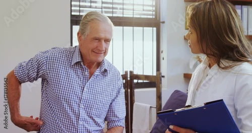 Physiotherapist assisting senior man while consulting 