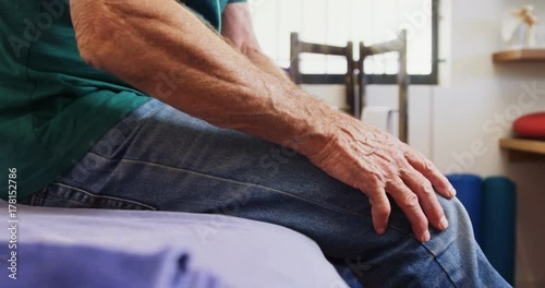 Senior man suffering from leg pain in clinic 