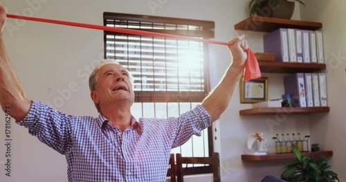 Senior man exercising with resistance band 