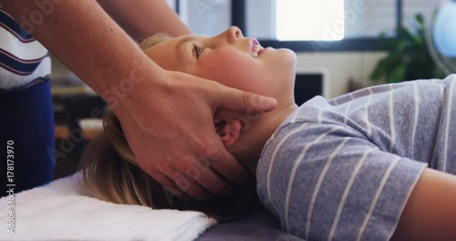 Physiotherapist giving head massage to a boy 