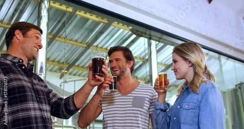 Brewers toasting beers at brewery 