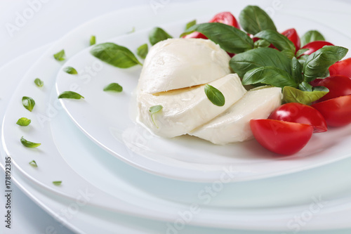 Mozzarella with tomato and green basil.