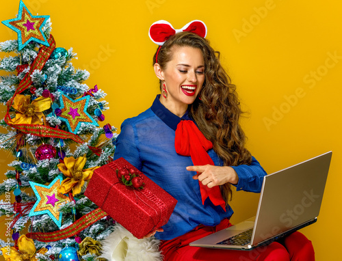 woman having video chat on laptop and showing present box