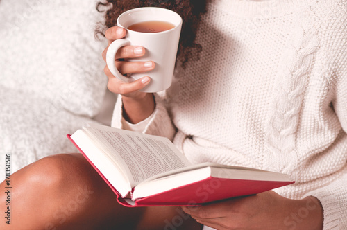 Hands holding book and mug