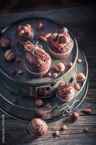 Homemade chocolate cupcake with nuts and brown cream