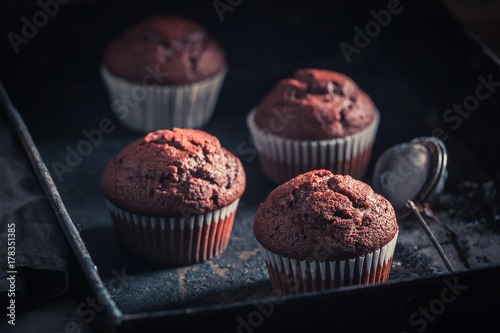 Yummy and sweet chocolate muffin on an old baking tray
