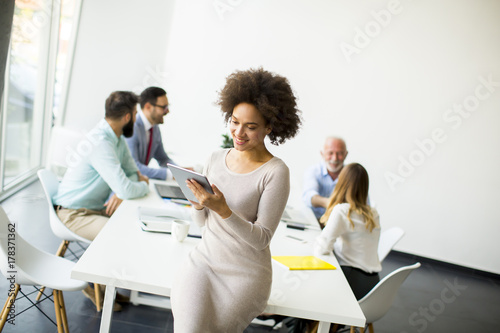 Smiling African woman using a tablet in office